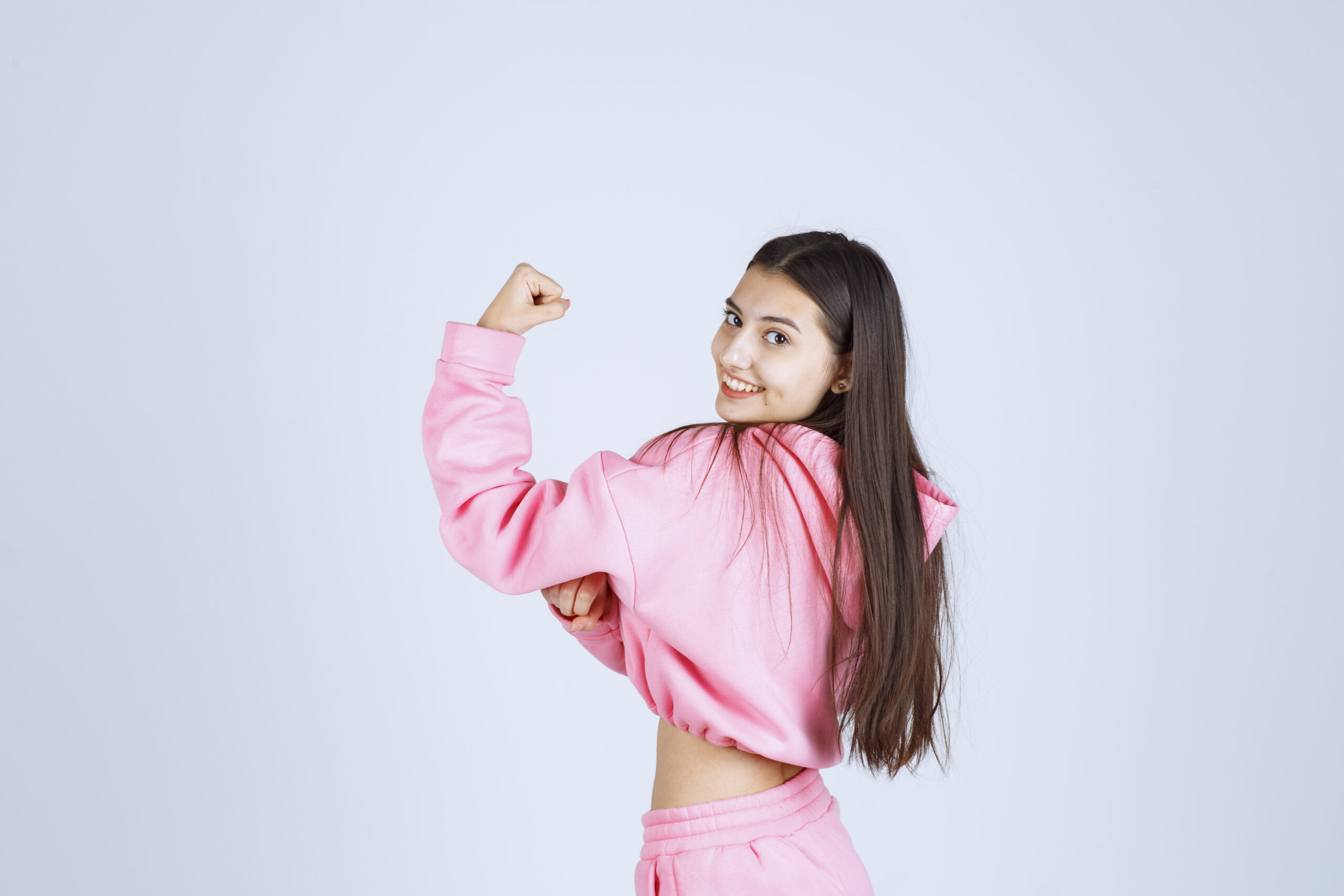 Girl in pink pajamas showing her fist and feeling powerful. High quality photo
